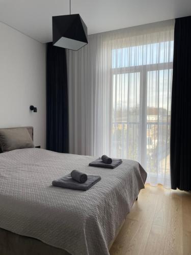 a bedroom with a bed with two towels on it at Dineikos apartamentai in Druskininkai