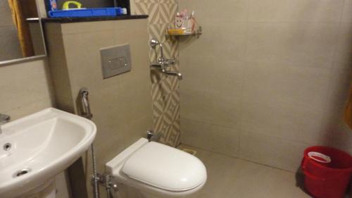 a bathroom with a white toilet and a sink at Green Hills Hideaway in Karandi Khurd