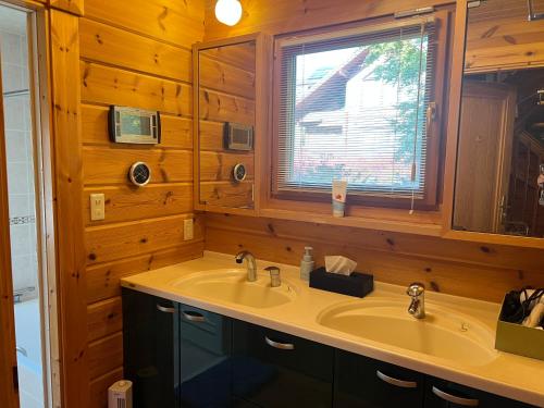 baño con lavabo y ventana en 山中湖湖畔高級ログハウス 充電富士168 en Yamanakako