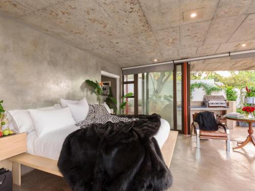 een slaapkamer met een groot bed en een zwarte deken bij Milner Fashion House in Pretoria