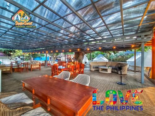 a patio with a wooden table and chairs at Siquijor Glamping Village in San Juan