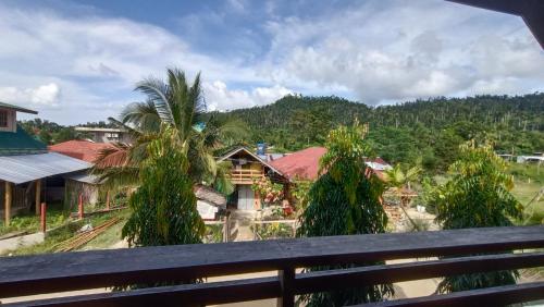 a view from the balcony of a house with palm trees at KALAYAAN INN in Port Barton