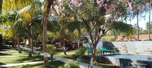 a resort with a swimming pool and palm trees at Pandan Bungalow in Gili Air