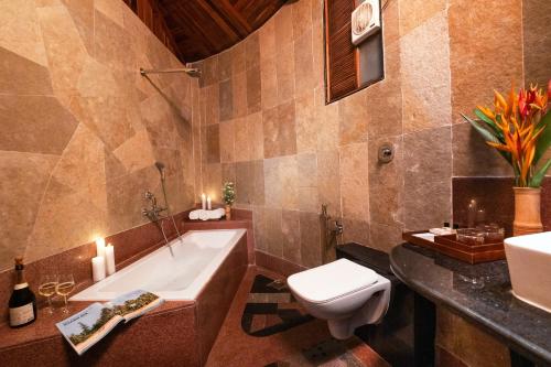 y baño con bañera, aseo y lavamanos. en ama Stays & Trails Eden Farms Paradise, Goa, en Goa