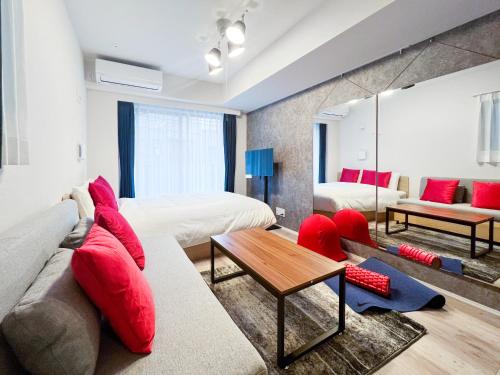 a living room with a couch and red pillows at KISETSU Waseda I in Tokyo