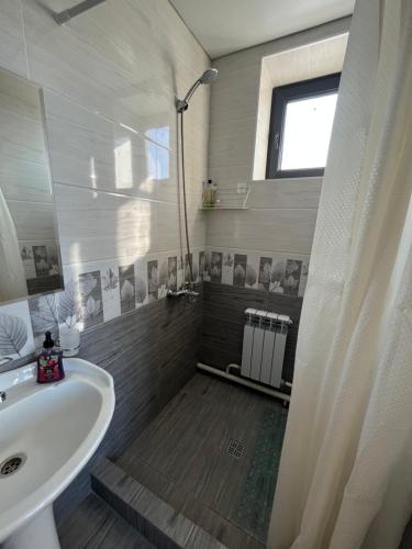 baño con lavabo blanco y ventana en Karakol Yurt Lodge & Homestay, en Karakol