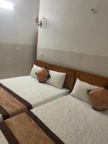 two beds sitting next to each other in a room at Hưng Phát Hotel Phú Yên in Phu Yen
