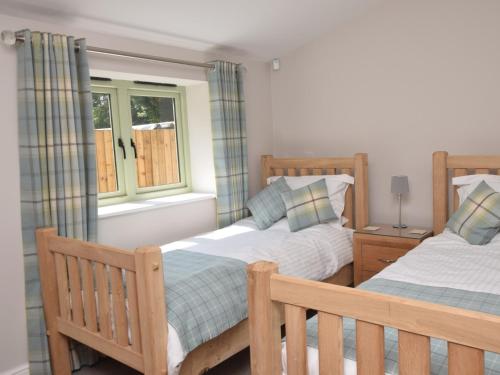 a bedroom with two beds and a window at 2 Bed in Croes-y-pant 58961 in Mamhilad