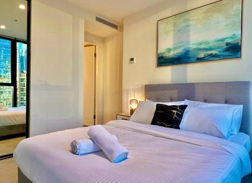 a bedroom with a large bed with two towels on it at Highrise Best Location 2 Bedrooms & 2 Bathrooms in Melbourne
