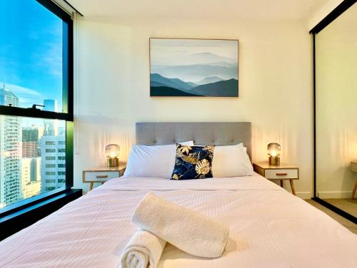 a bedroom with a large bed and a large window at Highrise Best Location 2 Bedrooms & 2 Bathrooms in Melbourne
