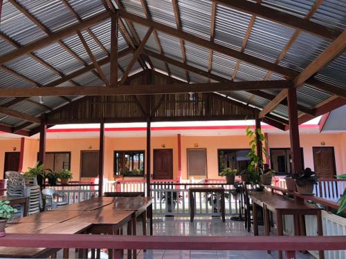 a cafeteria with wooden tables and benches in a building at JBR Tourist Inn - Port Barton in Itaytay