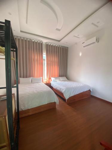 a bedroom with two beds and a window at Cao Son Hotel in Bắc Quang