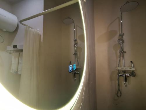 een badkamer met een ronde spiegel en een douche bij 此时此刻民宿This Moment B&B in Miyun