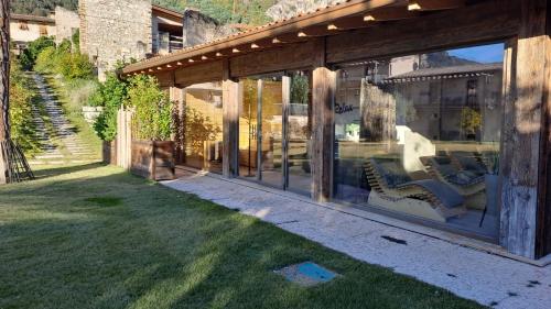 a glassconservatory with a view of a yard at Sibenbras Natural Aparthotel in Limone sul Garda