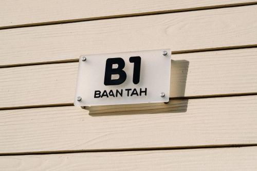 a sign on the side of a wooden building at Baan Tah On The Sea in Bang Sare