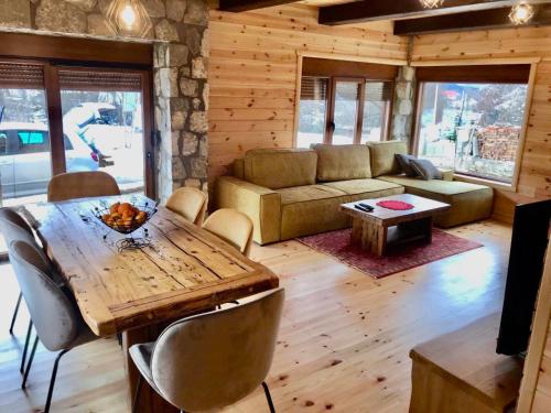 a living room with a table and a couch at Chalet Blanc in Kolašin