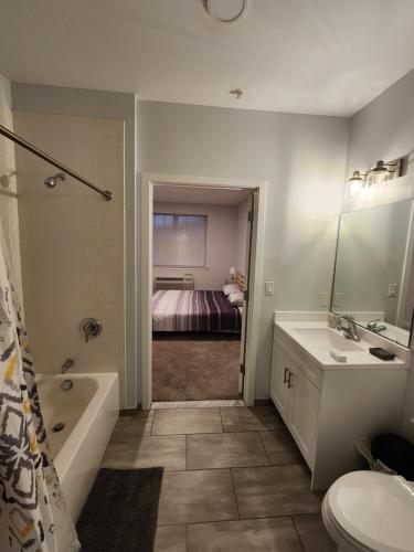 a bathroom with a sink and a toilet and a bed at Modern 2 bed apt, mins to NYC! in Jersey City