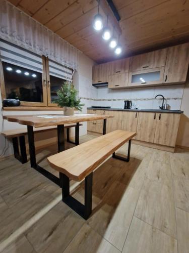 a kitchen with a wooden table and a bench at Domek Aniula in Istebna