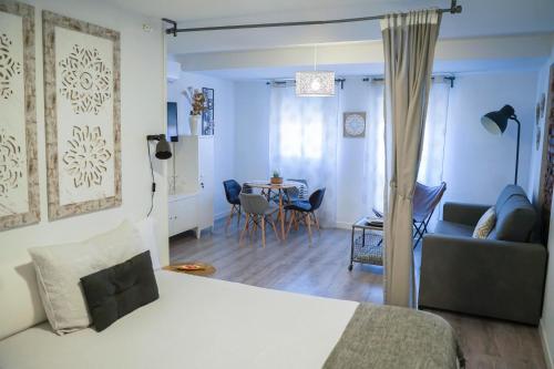 a bedroom and living room with a bed and a table at Apartamentos Suites Cariátide in Plasencia