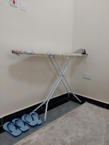 a shelf in a room with blue slippers on the floor at One Bedroom, Lake View with GYM in Nakuru