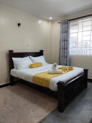 a bed with a teddy bear sitting on top of it at One Bedroom, Lake View with GYM in Nakuru