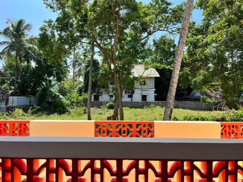 um banco laranja num parque com uma casa ao fundo em BAVA Lalitha Retreat Center Varkala em Varkala