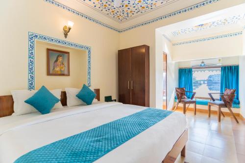 um quarto com uma cama grande e detalhes em azul em Natural Lake View Hotel em Udaipur