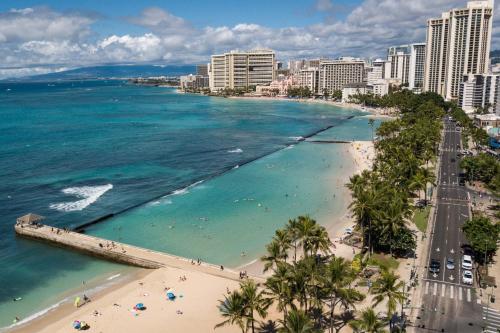 a view of a beach with palm trees and the ocean at High Floor Luxury Oceanfront at Waikiki Beach Tower in Honolulu