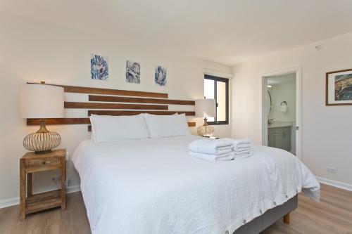 a bedroom with a white bed with towels on it at High Floor Luxury Oceanfront at Waikiki Beach Tower in Honolulu