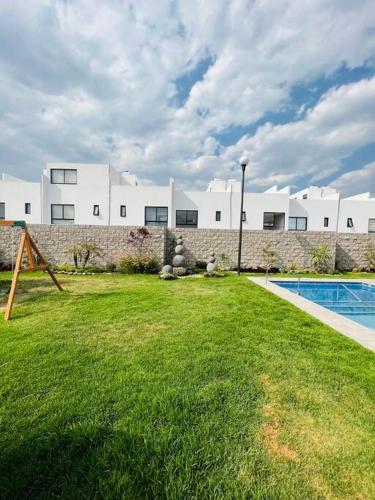 a house with a yard with a swimming pool at Casa en Fraccionamiento Privado con alberca in Cuautlancingo