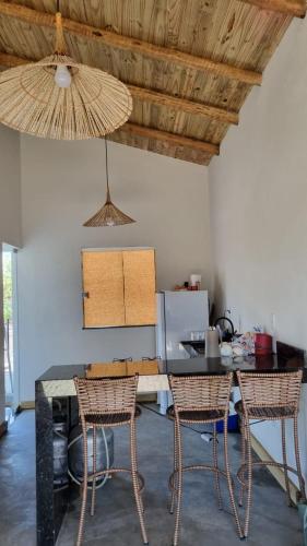 une cuisine avec une table et deux chaises et un plafond dans l'établissement Casinha em Caraíva, à Porto Seguro