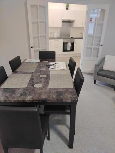 a dining room table with chairs and a kitchen at Modern 2 bed house sleeps 6 in Portsmouth