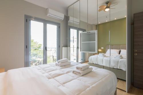 a bedroom with two beds and a large mirror at Stratum Apartment by LobbySquare in Athens