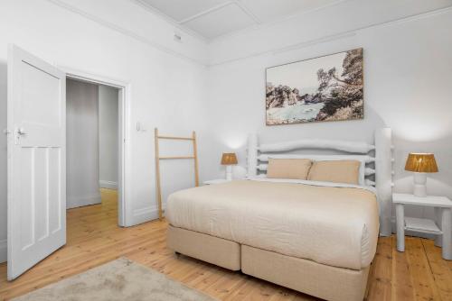 een witte slaapkamer met een bed en een foto aan de muur bij Wanderlust Cottage Grange in Grange