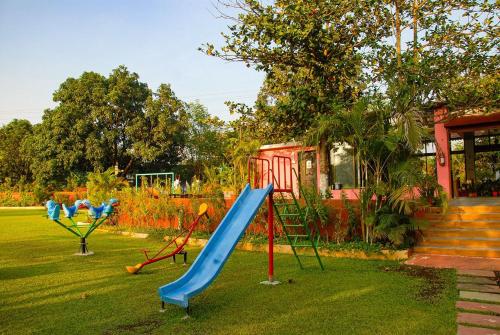 einen Spielplatz mit einer blauen Rutsche im Hof in der Unterkunft Ashoka Lawns and Resort in Alibag