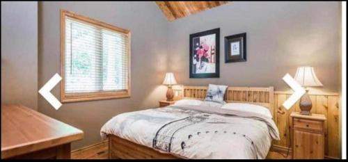 a bedroom with a bed and a desk and a window at WATERFRONT LUXURY HOUSE/CHALET in Ragged Rapids