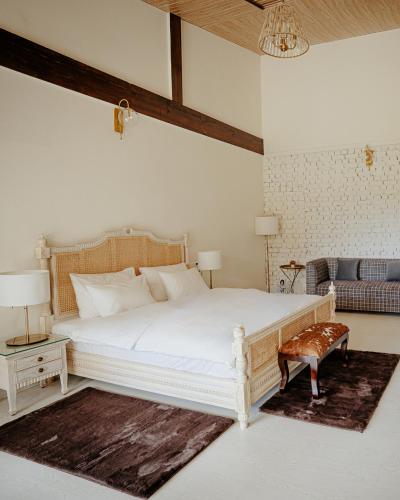 a bedroom with a large white bed and a couch at Ekaa House in Manāli