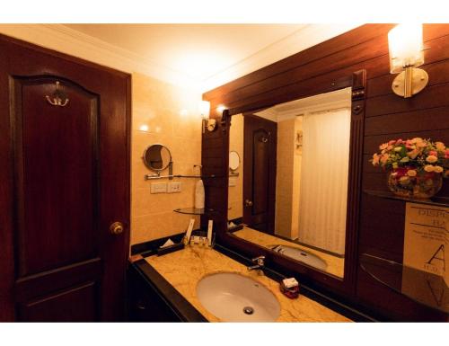 een badkamer met een wastafel en een grote spiegel bij A Hotel, Ludhiana in Ludhiana