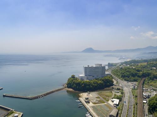 an aerial view of a large building next to the water at Grand Mercure Beppu Bay Resort & Spa in Beppu