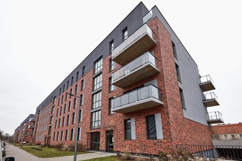 un edificio de ladrillo rojo con balcones en una calle en Żelazna Modern Studio, en Poznan