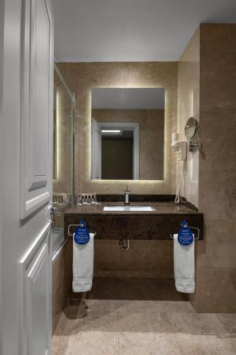 a bathroom with a sink and a mirror and towels at Rotta Hotel Istanbul in Istanbul