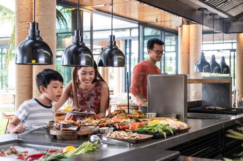 a woman and a child preparing food in a kitchen at Sailing Club Signature Resort Phu Quoc in Phu Quoc