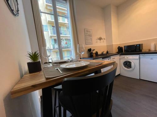 une cuisine avec une table et des chaises ainsi qu'une fenêtre dans l'établissement Charmant Studio - Port de Nice, à Nice