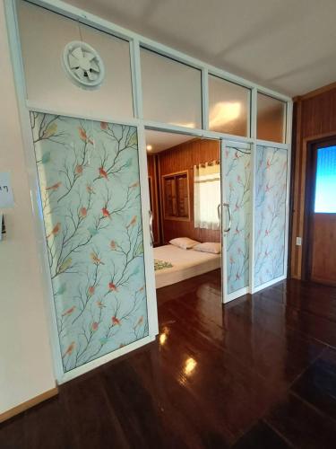 a room with sliding glass doors with a bedroom at บ้านสุขใจ อัมพวา in Samut Songkhram