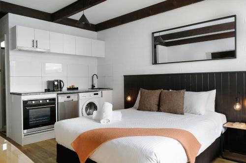 a bedroom with a large bed and a kitchen at m hotel in Sale