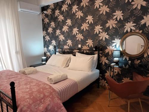 Schlafzimmer mit einem Bett mit Blumentapete in der Unterkunft Stunning apartment in the heart of Athens in Athen