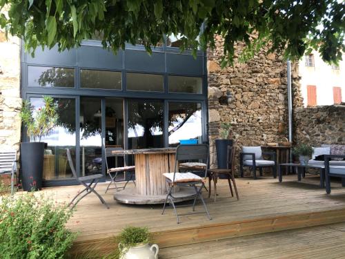 un patio avec des chaises et des tables en face d'un bâtiment dans l'établissement Chambre spacieuse Le clos des vignes, à Chavanay