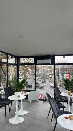 a restaurant with tables and chairs and a large window at Grey Boutique Hotel Palas in Iaşi
