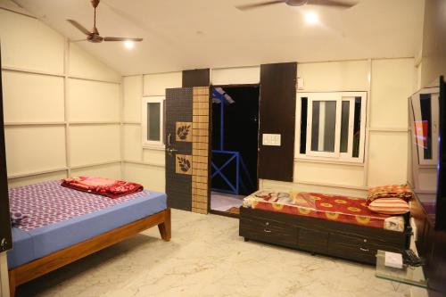 a bedroom with two beds and a mirror at Rainbow Residency in Yelagiri