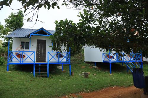 a blue and white house with a tree at Rainbow Residency in Yelagiri